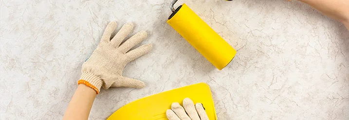 Zwei Personen tapezieren mit Tapezierspachtel und Walze